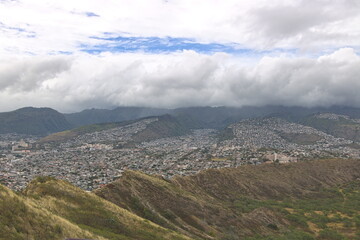 Fototapeta premium Clouds cover the Koolau mountain range just behind the residential neighborhoods of Honolulu
