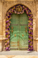 Old green door decorated with colorful dried flowers, Alicante - Spain