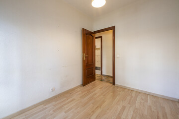 Small empty room with laminated flooring and sapele wood access door