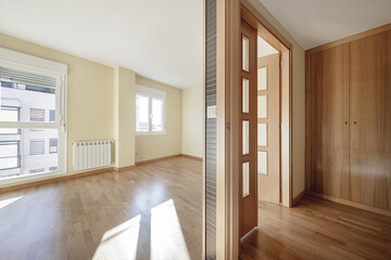 Empty room with light oak hardwood floors in a loft apartment with double glassed wooden doors and matching wooden built-in wardrobes