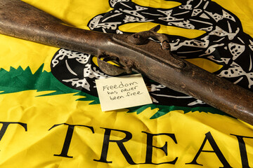 old musket rifle on yellow don't tread on me flag with freedom has never been free note