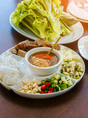 Close up to dipping sauce for Vietnamese Meatball Wraps (Nam-Neung), Pork Sausage wraps with fresh vegetables in rice paper, generous platter eat with sweet sauce. Vietnamese Pork Sausage and salad.