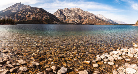 Fototapeta na wymiar Clear lake with pebbles and mountains
