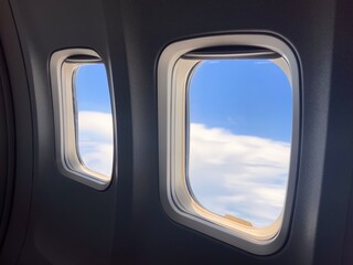Duas janelas de avião com o céu ao fundo