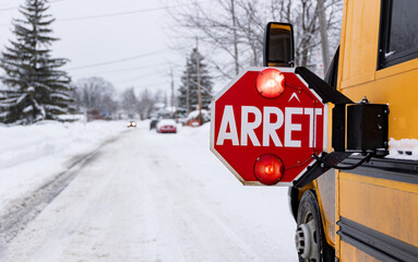 Panneau arrêt d'autobus scolaire sur rue enneigée  © Nicolas St-Germain