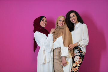 Group portrait of beautiful muslim women two of them in fashionable dress with hijab isolated on...
