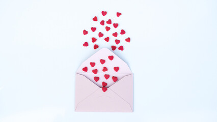 Pink paper envelope with Valentines hearts on white background. Flat lay, top view. Romantic love letter for Valentine's day concept.