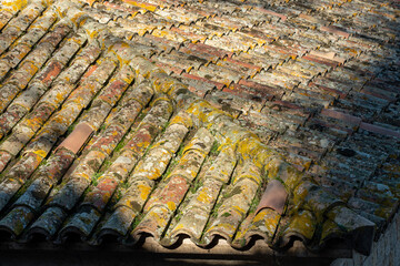 detail of the roof of an ancient wall tiles with the tile in the view of the city center of Girona.