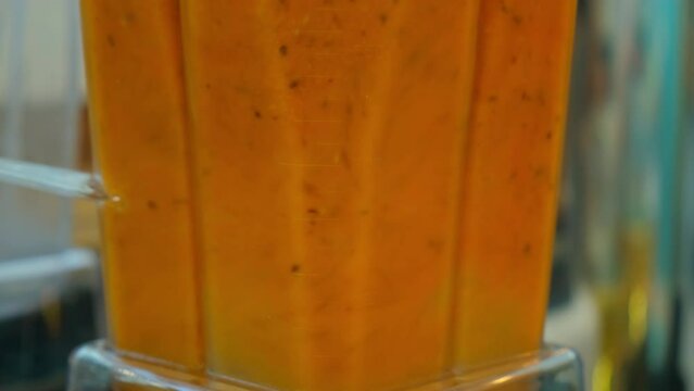 blender grinds sea buckthorn. Mango fresh in a blender. A sea buckthorn, orange drink is whipped in a blender
