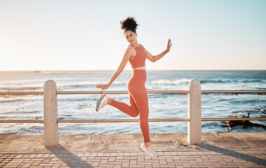 Fototapeta na wymiar Fitness, happy running and woman jumping on beach path on fun morning exercise with freedom and happiness. Run, jump and smile, excited girl on healthy ocean walk with joy, wellness and workout goals