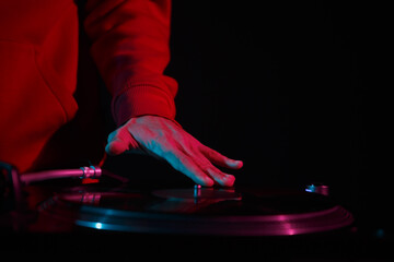 Disc jockey scratching vinyl record on turn table player. Hip hop DJ plays music on party in night...