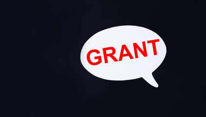 On a black background, a white figured card with the text GRANT. Copy space