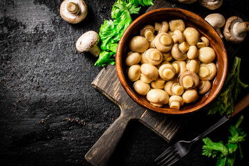 Delicious pickled mushrooms on a cutting board. 