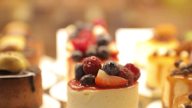 Pastisseria. Cheesecake decorated with berries on the counter in a local bakery. Delicious cakes with caramel, marzipans and raspberries. Italian and French desserts.