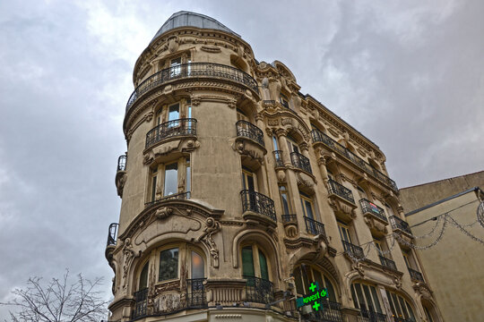 Saint-Etienne, France - January 27th 2020 : Focus on an old building, built in haussmannian style. There's a pharmacy on the ground floor. This kinf of building is rare in Saint-Etienne.