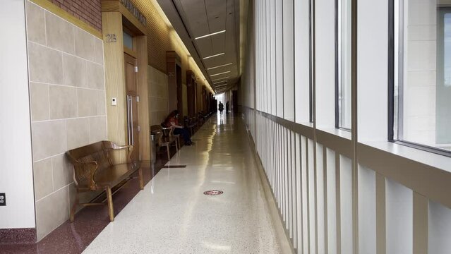 Richmond County courthouse interior lady wearing face mask on phone sitting on a wooden bench