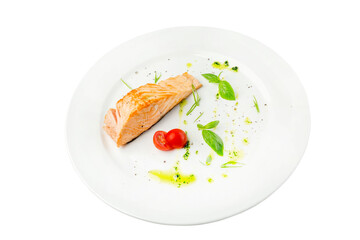 Grilled piece of salmon with sauce and cherry tomato on a white plate. A beautifully served portion of an appetizing dish. Top view. Close-up. Isolated on white background.