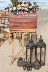 A welcome board sign with a beautiful flower rustic decoration, standing in front of wedding...