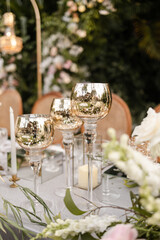Luxury table settings for fine dining with glassware, flowers and candles in art deco style. Props for events, weddings, birthdays, gala banquet.