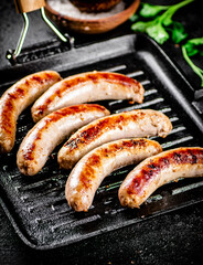Grilled sausages in a frying pan with parsley. 