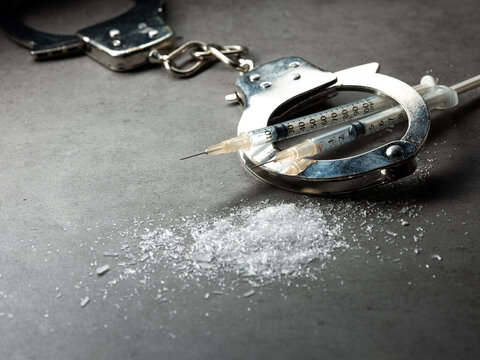 Handcuffs, drug syringe and drug powder	