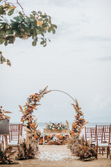 Rustic wedding set up on beach. Beautiful tropical outdoor ceremony or party with ocean view. Destination weddings concept - 563981956