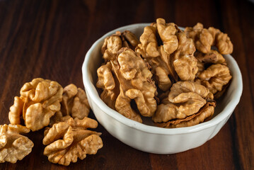 bowl of Shelled walnut wooden table healthy food Close-up  kernels and whole walnuts on rustic old.