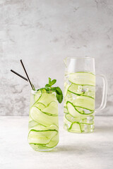 Fresh infused cucumber water on a light background
