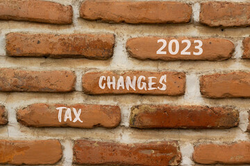 Tax changes 2023 symbol. Concept words Tax changes 2023 on red brown brick wall on a beautiful brick wall background. Business Tax changes 2023 concept. Copy space.