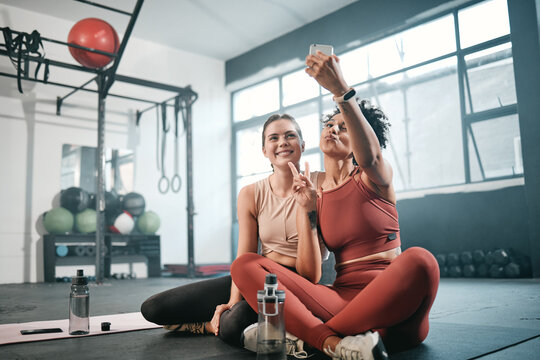 Gym, phone or friends take a selfie with peace sign after fitness training, workout or exercise for social media. Memory, sports girls or happy women take a photo or picture relaxing on fun break