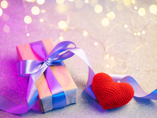 valentine's day gift , gift box with purple ribbon and red heart, bokeh background