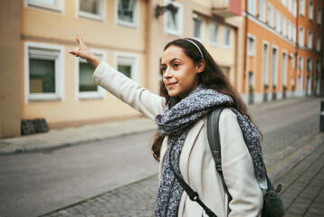 Woman, travel or hailing taxi in city, street or New York road in transportation, traveling or urban commute. Tourist, student or person waiting for cab, lift stop or sightseeing bus in town location