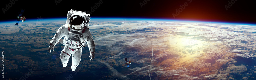 Wall mural an astronaut in a white spacesuit hanging in space against the backdrop of planet earth. copy space