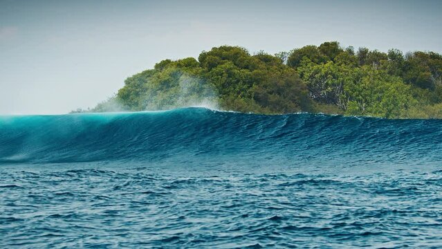 Big ocean wave breaks in the Maldives and covers the island