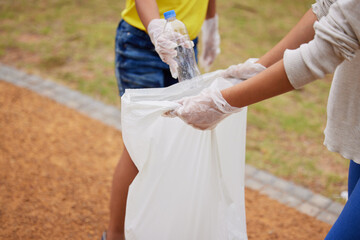 Charity, earth day and volunteer cleaning trash for climate change outdoors at park to recycle for...