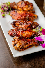 
Chicken wings. Buffalo chicken wings. American cuisine of chicken wings deep-fried, dipped in buffalo sauce made of vinegar,  cayenne hot sauce and butter. Served with celery, carrots, blue cheese.