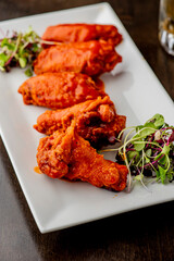 
Chicken wings. Buffalo chicken wings. American cuisine of chicken wings deep-fried, dipped in buffalo sauce made of vinegar,  cayenne hot sauce and butter. Served with celery, carrots, blue cheese.