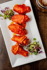 
Chicken wings. Buffalo chicken wings. American cuisine of chicken wings deep-fried, dipped in buffalo sauce made of vinegar,  cayenne hot sauce and butter. Served with celery, carrots, blue cheese.