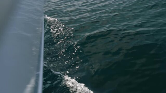 The bow of the white yacht cuts the waves. Slow motion