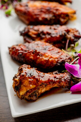 
Chicken wings. Buffalo chicken wings. American cuisine of chicken wings deep-fried, dipped in buffalo sauce made of vinegar,  cayenne hot sauce and butter. Served with celery, carrots, blue cheese.