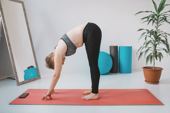 short hair blonde in a black short top and leggings is doing yoga on a mat. A girl with a little extra weight and folds at the waist is doing Pilates and plank. Body positivity and self acceptance