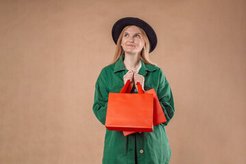 Cheerful pretty 20s blonde woman with packages in hands shopping blue background. High quality photo