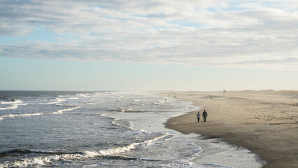 Elderly couple walking on beach 