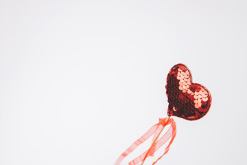 Red heart in sequins on a white background. Valentine's Day background. Top view