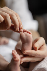 newborn baby feet on mom and dad hands. happy family concept	