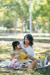 Little girl and her grandmother enjoying in picnic together