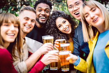 Front view of friends drinking and toasting beer at brewery bar restaurant patio - Happy hour promotion concept with people having fun together inviting guest at brew outdoor pub - Bright vivid filter - obrazy, fototapety, plakaty