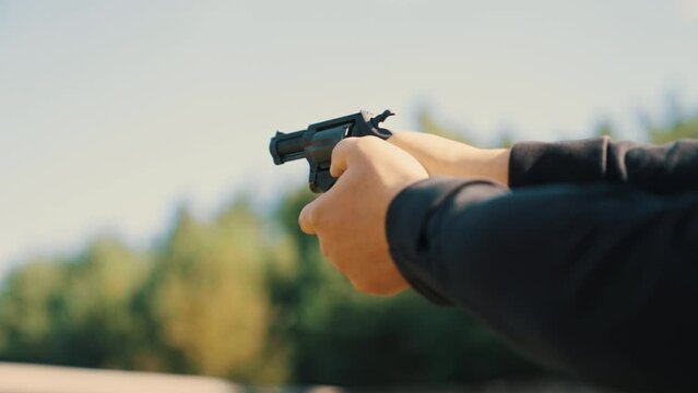 Hands of a man shooting a pistol with a revolving cylinder. High quality 4k footage