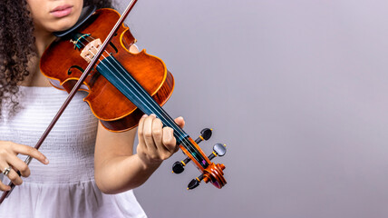 Classical music concept. Copyspace. Young girl plays violin on grey background. - obrazy, fototapety, plakaty