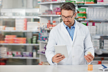 Pharmacist man, shop and reading with tablet, medicine, pills and counter for health, medication or...
